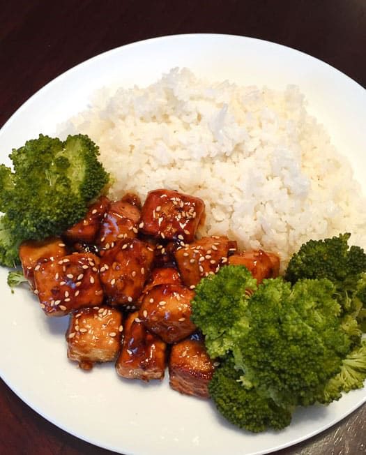 vegan general tso tofu with broccoli and rice on a plate, as seen from above.