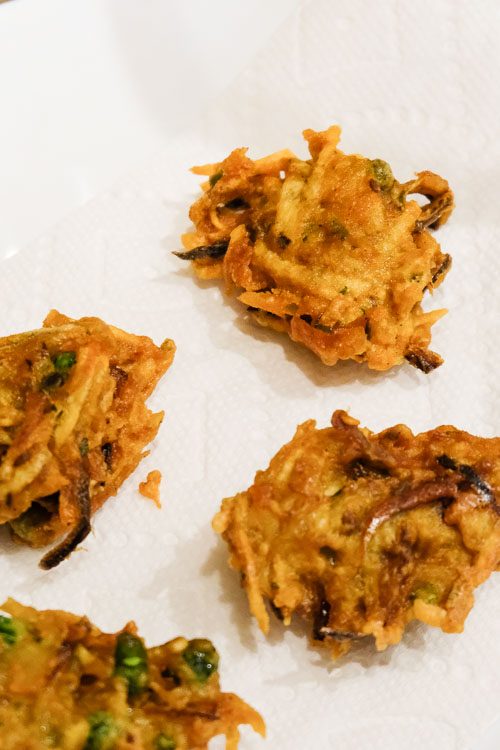 Fried pakora draining on a paper towel.
