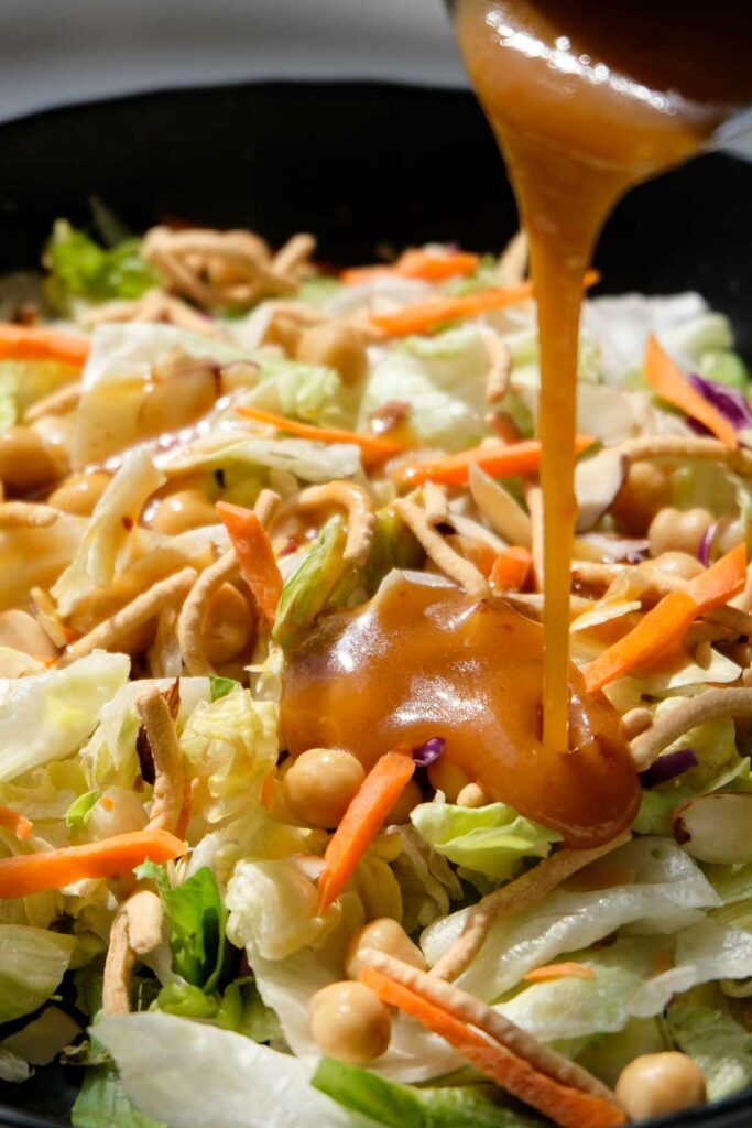 Asian Chickpea Salad with dressing pouring on.