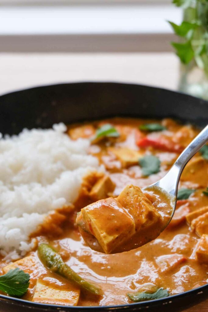 The finished vegan butter chicken with rice, being scooped up on a spoon.
